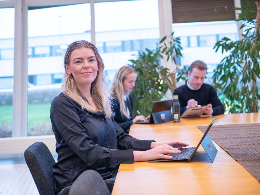 Nyutexaminerad person förbereder sin jobbansökan med CV och laptop vid ett kontorsbord.